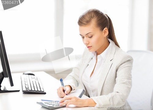 Image of businesswoman with notebook and calculator