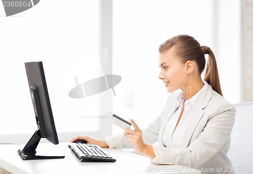 Image of businesswoman with computer using credit card