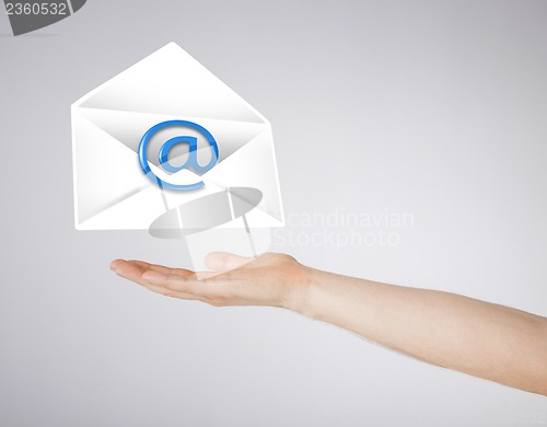 Image of hand holding envelope with email sign