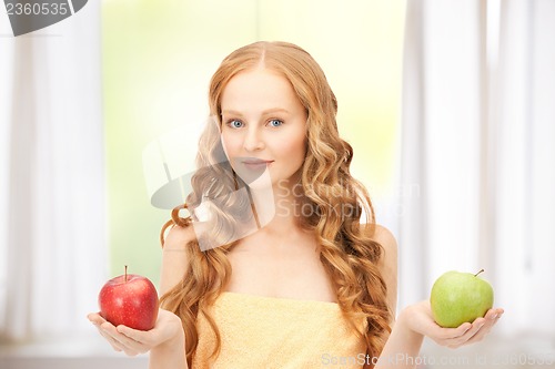 Image of young beautiful woman with green and red apples