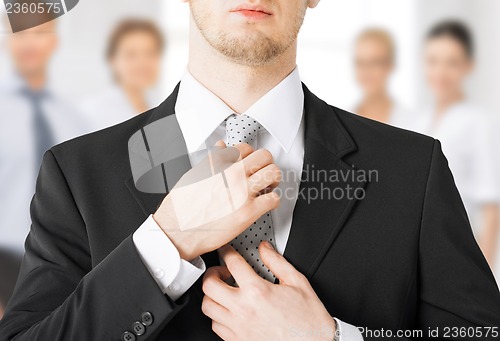 Image of man adjusting his tie