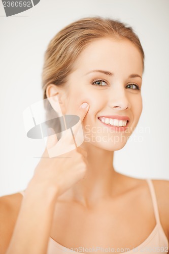 Image of woman pointing at her cheek