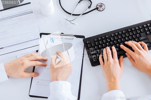 Image of doctor and nurse writing prescription paper