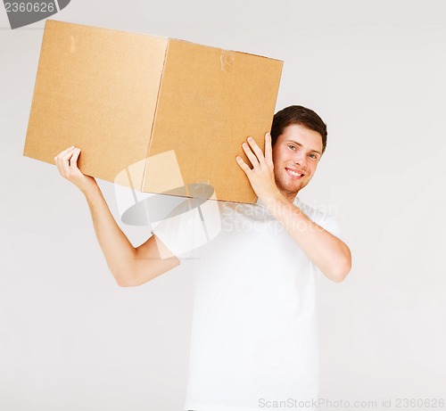 Image of smiling man carrying carton box