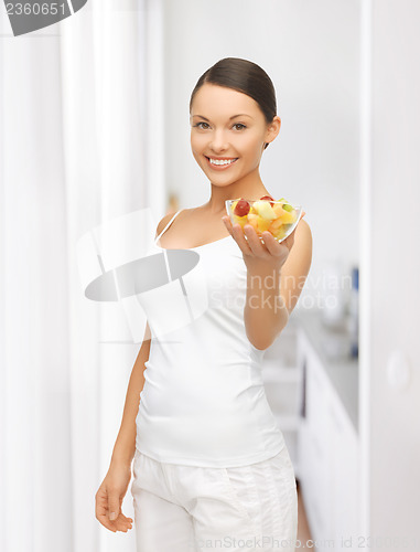 Image of healthy woman holding bowl with fruit salad