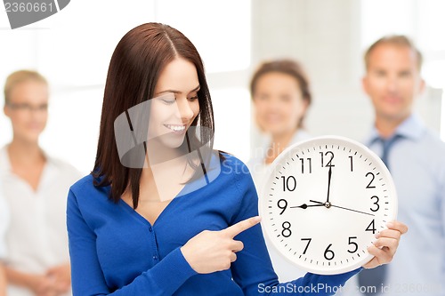 Image of woman holding big clock