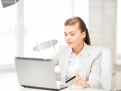 Image of businesswoman with laptop using credit card