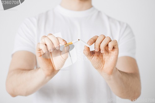 Image of man breaking the cigarette with hands