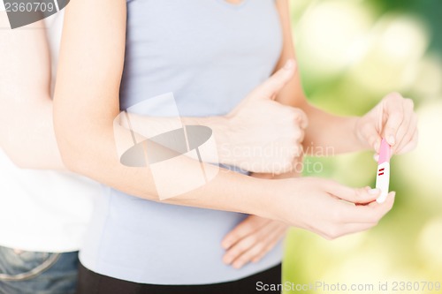 Image of woman and man hands with pregnancy test