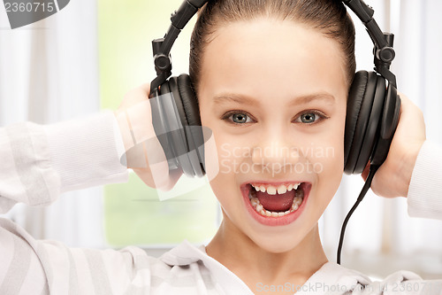 Image of happy teenage girl in big headphones
