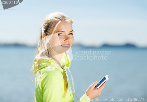 Image of woman listening to music outdoors