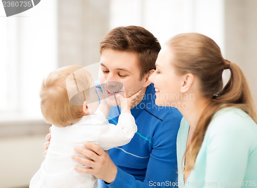 Image of happy parents playing with adorable baby