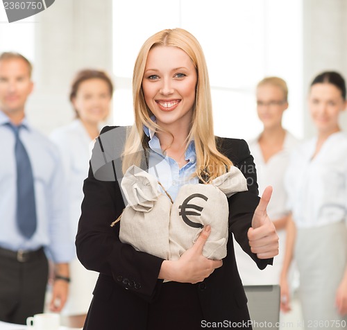 Image of businesswoman with money bags showing thumbs up