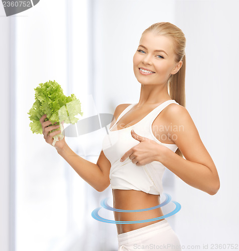 Image of sporty woman with lettuce showing abs