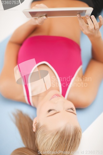 Image of woman lying on the floor with tablet pc