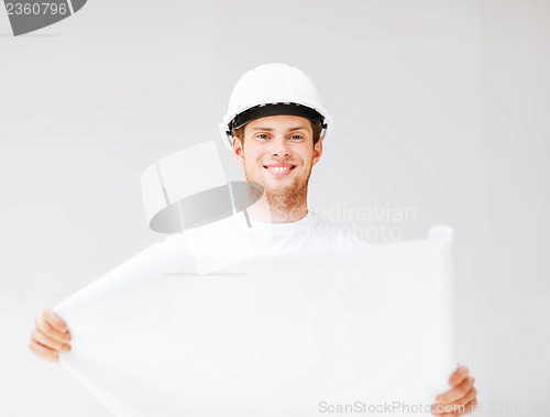 Image of male architect in helmet with blueprint