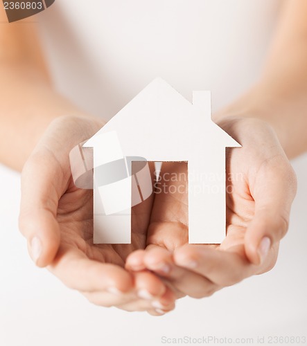 Image of woman hands holding paper house