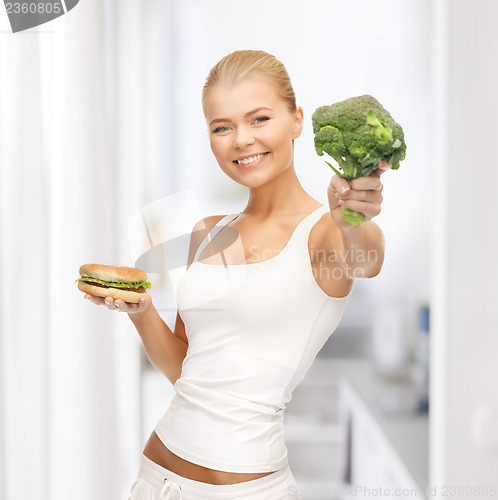 Image of woman with broccoli and hamburger