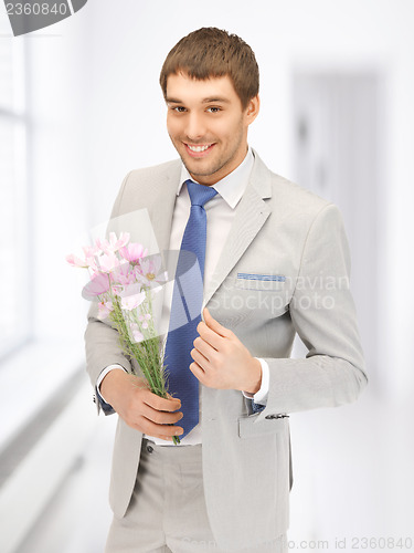 Image of handsome man with flowers in hand