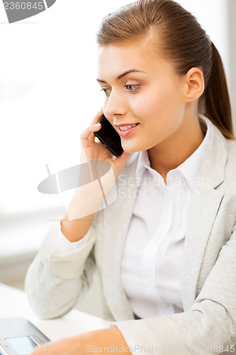 Image of businesswoman with smartphone in office