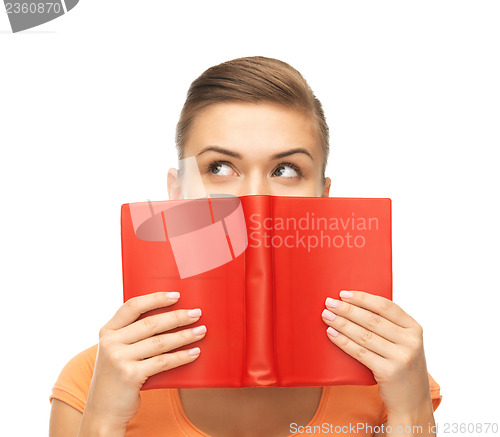 Image of woman eyes and hands holding red book