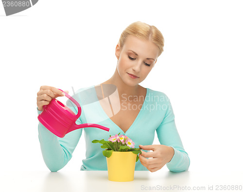 Image of housewife with flower in pot and watering can