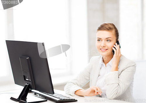 Image of businesswoman with smartphone in office