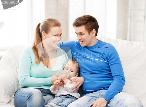 Image of family and adorable baby with feeding-bottle