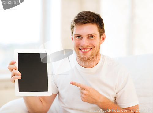 Image of man pointing at tablet pc at home