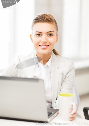 Image of businesswoman with laptop in office