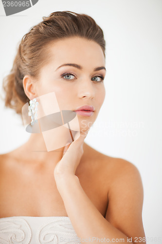 Image of woman wearing shiny diamond earrings