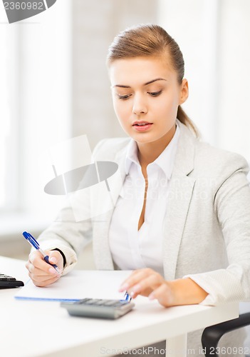 Image of businesswoman with notebook and calculator