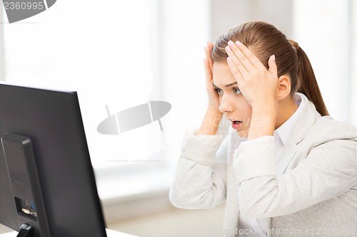 Image of stressed student with computer in office