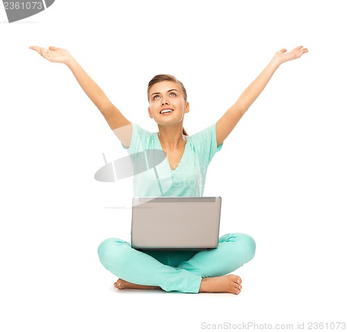 Image of happy girl sitting on the floor with laptop