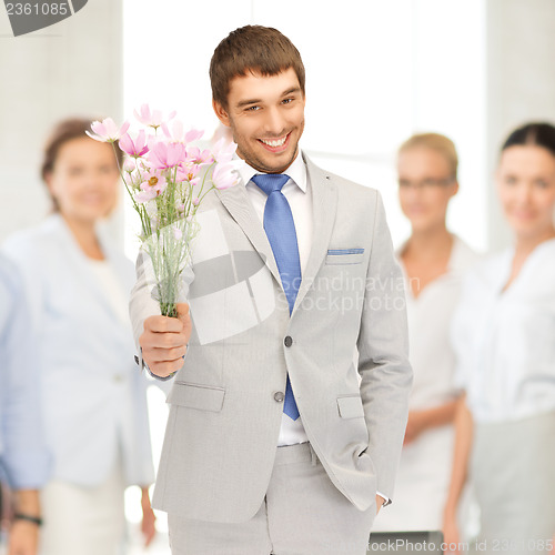 Image of handsome man with flowers in hand