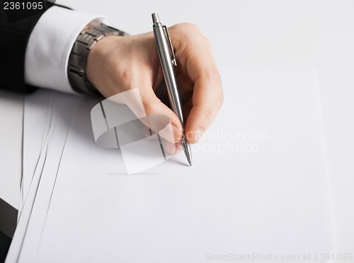 Image of businessman writing something on the paper