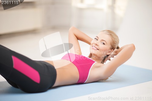 Image of sporty woman doing exercise on the floor
