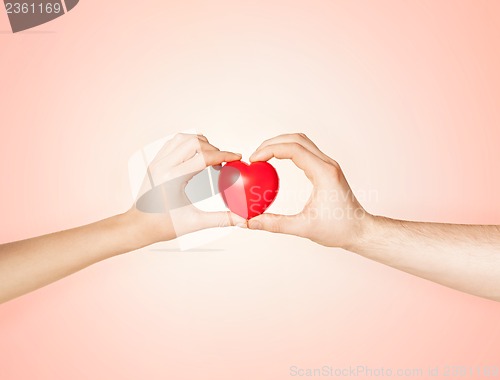 Image of woman and man hands with heart