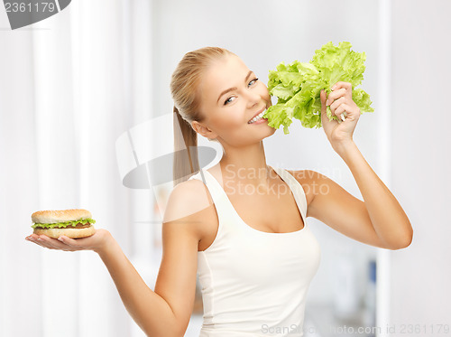 Image of woman with green lettuce and hamburger