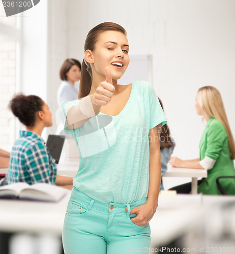 Image of smiling girl in color t-shirt showing thumbs up