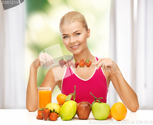 Image of woman with organic food eating strawberry