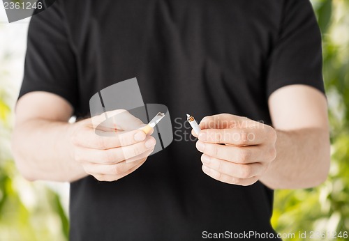 Image of man breaking the cigarette with hands