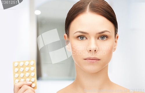 Image of young beautiful woman with pills