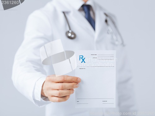 Image of male doctor holding rx paper in hand