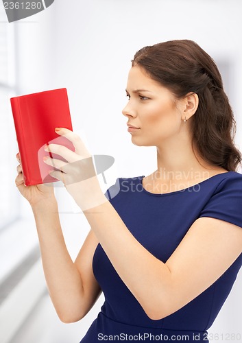 Image of calm and serious woman with book