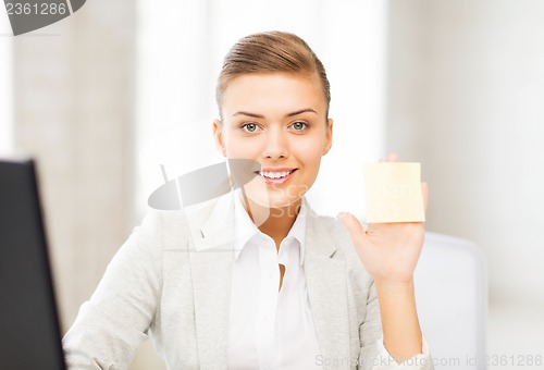 Image of smiling businesswoman showing sticky note