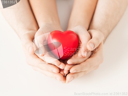 Image of woman and man hands with heart