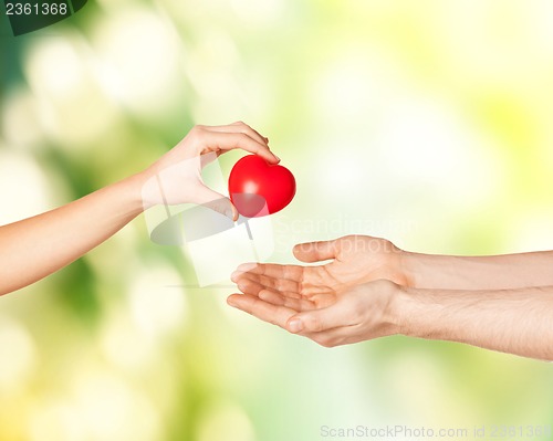 Image of woman and man hands with heart