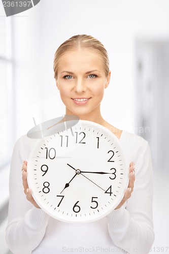 Image of woman holding big clock