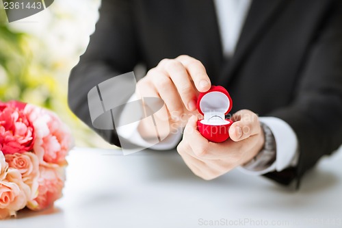 Image of man with gift box and wedding ring